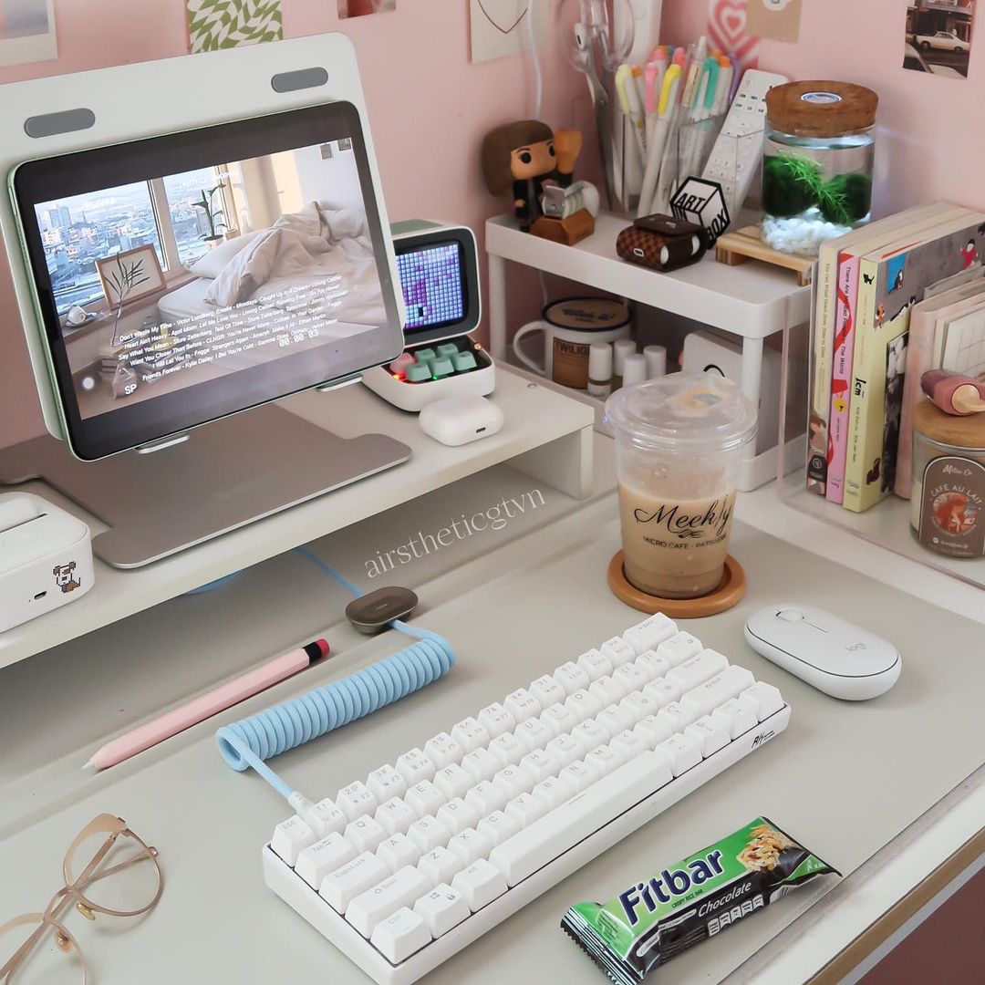 Minimalist desk setup featuring a Royal Kludge RK61 best budget gaming keyboard, a tablet, and stationery items on a light-colored desk