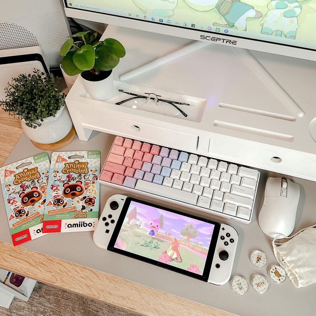 Stylish workspace with a Royal Kludge RK61 hot swappable keyboard, a Nintendo Switch, and colorful stationery in a cozy setting