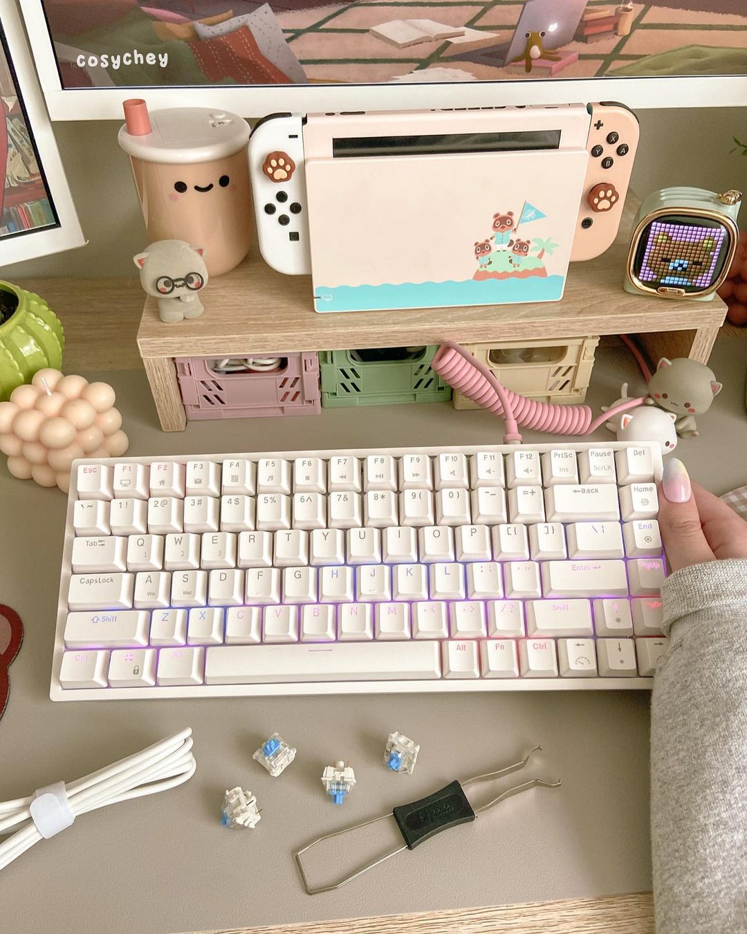 RK Royal Kludge RK84 keyboard with customizable RGB backlighting, displayed on a work desk alongside a laptop and plants