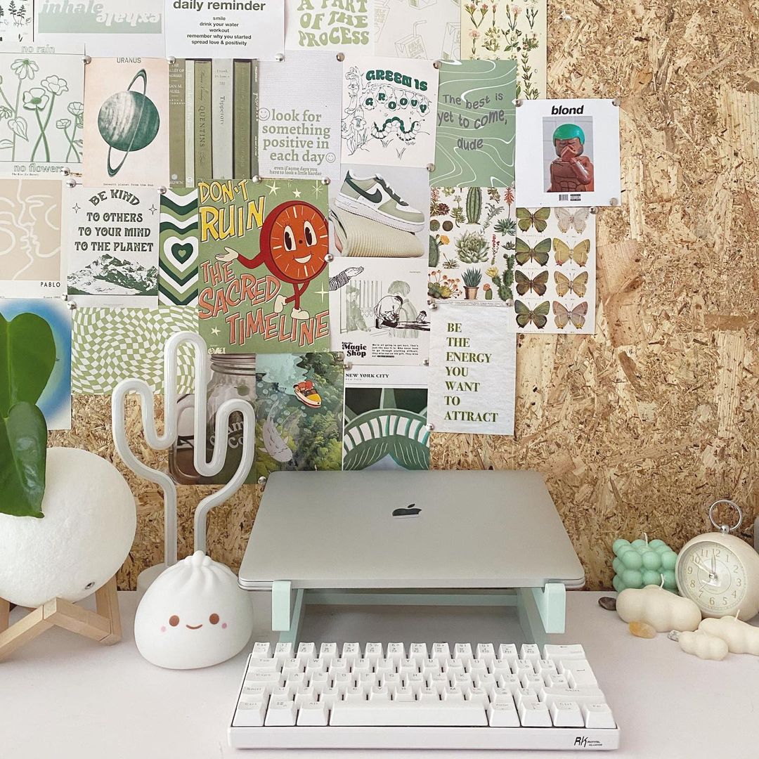 Creative workspace with a Royal Kludge RK61 60% compact mechanical keyboard, a laptop, and a collection of plants and decor elements