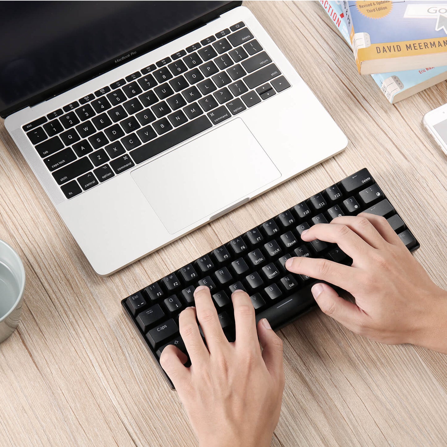 Person typing on the Black Royal Kludge RK61 white keyboard, showcasing its ergonomic design and 60% compact layout