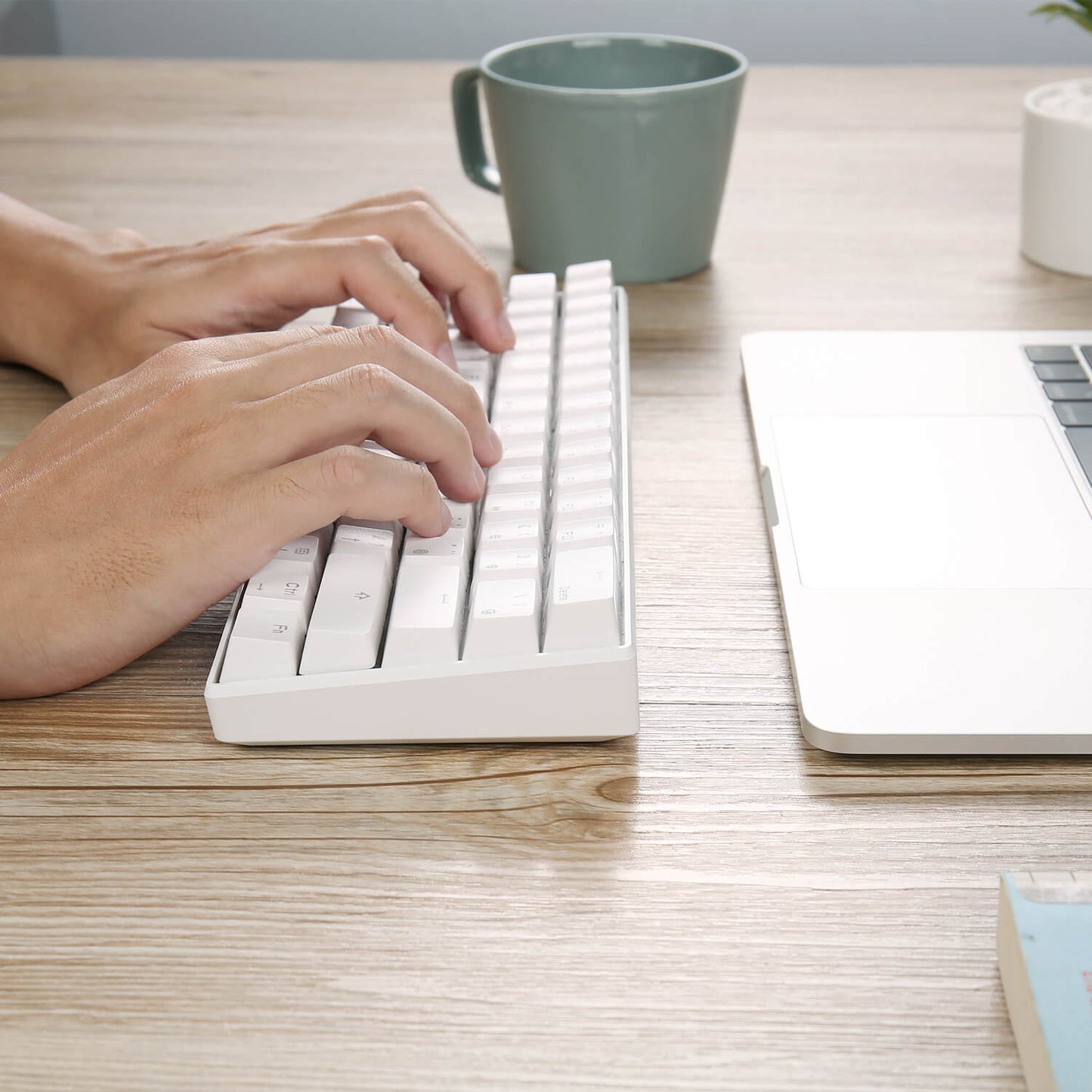 Person typing on the Royal Kludge RK61 white keyboard, showcasing its ergonomic design and 60% compact layout